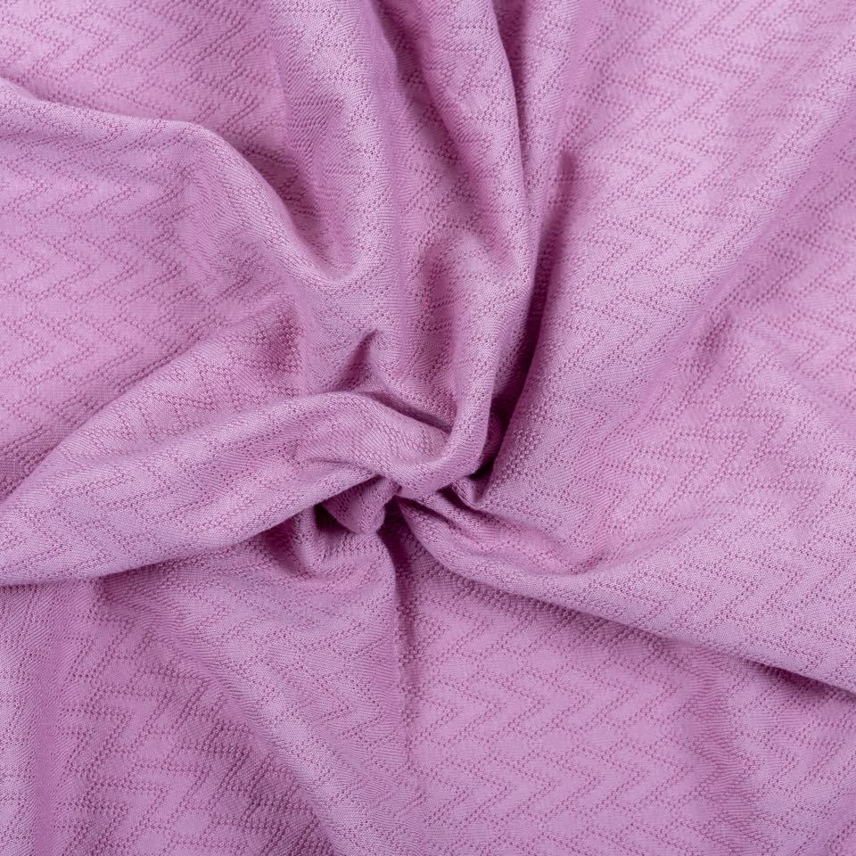 Lilac jacquard knit with a woven-in zigzag pattern, twisted into folds.